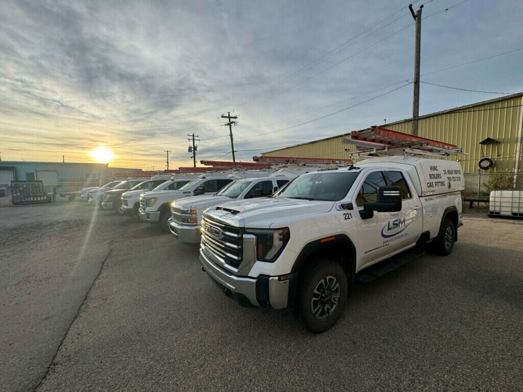 LSM Service Division service trucks lined up at sunrise outside the Grande Prairie shop