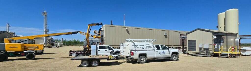 LSM Service Division service truck, boom lift and crane trailer at an oilfield lease site